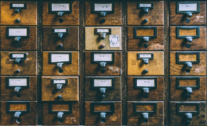 Rows of wooden card catalog drawers with label holders