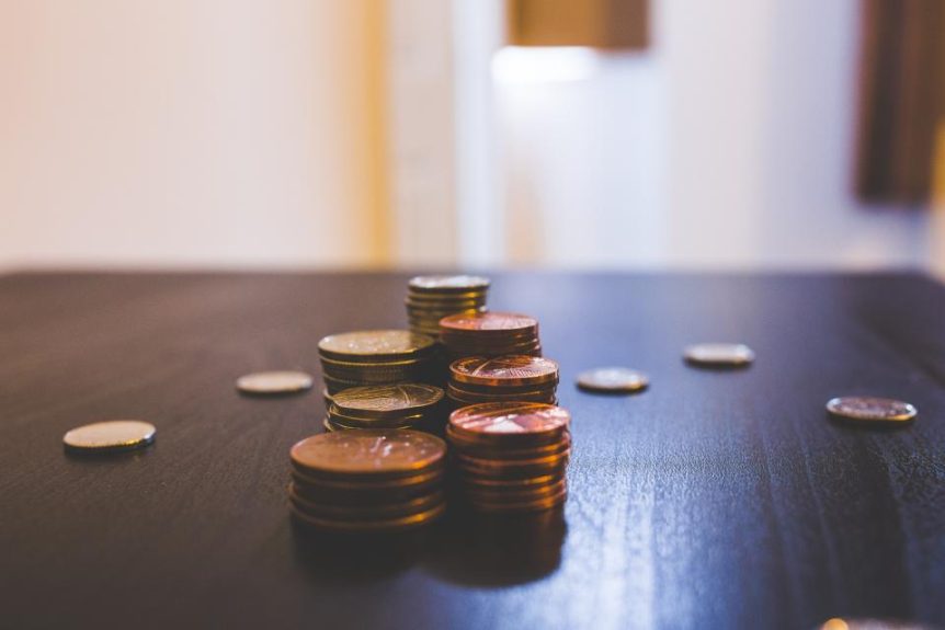 Stack of coins on a dark wooden table
