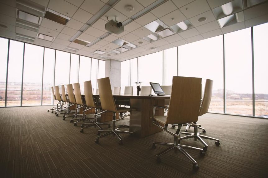 Empty modern conference room with a long table and office chairs