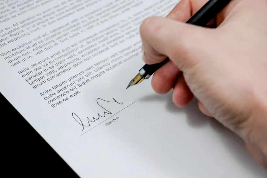 Hand signing a printed document with a fountain pen