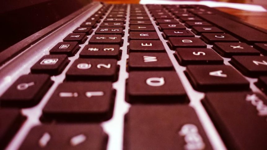 Close-up of a laptop keyboard in warm red light