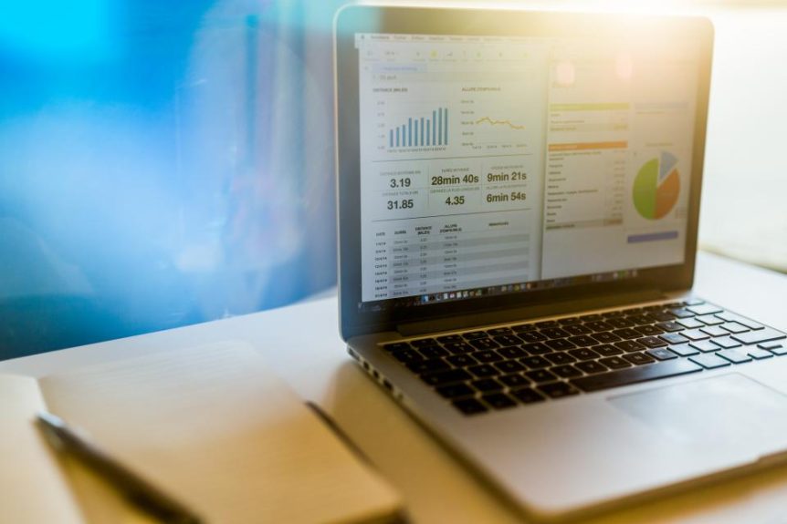 Laptop showing sales analytics charts on a desk
