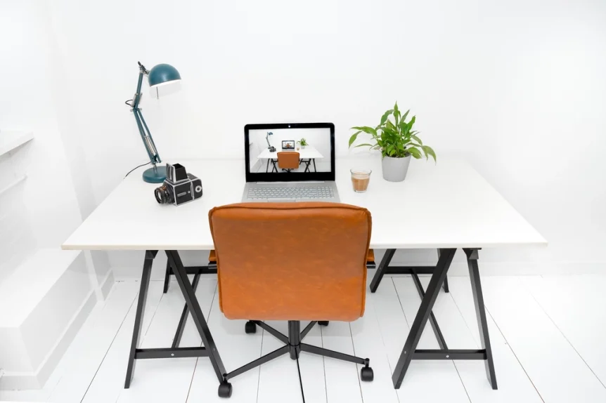 Minimal home office desk with a laptop, lamp and plant