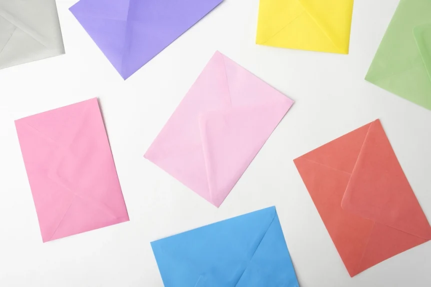 Pastel-colored envelopes scattered on a white surface