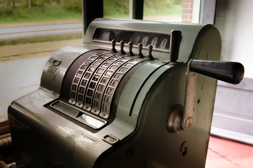 Vintage mechanical cash register beside a window