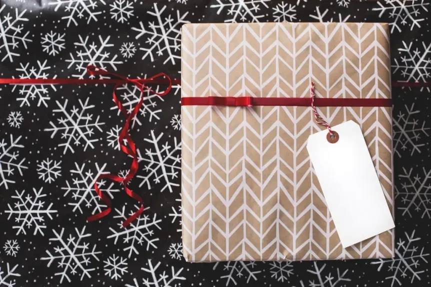 Wrapped gift with a blank tag on snowflake wrapping paper
